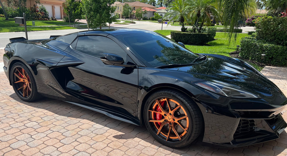 Black 2025 Corvette C8 E-Ray on Polished Bronze RVRN RV-DC24 super concave forged wheels, front view on a suburban street