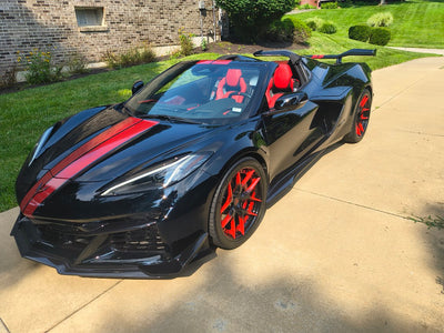 Front angle view of a black 2025 Corvette C8 Z06 with RVRN RV-DR08D custom forged wheels, deep dish Y-spoke style, and two-tone red black gradient finish.