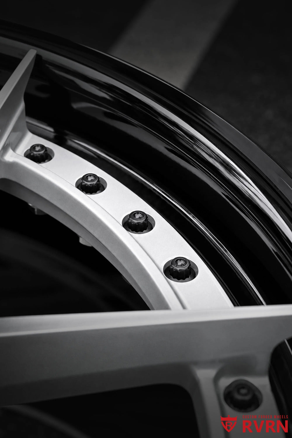 Close-up of the RV-DR08D 2-piece forged wheel rim for the 2026 Corvette C8 Stingray, showing the Gloss Black Barrel edge, silver spoke area, black fasteners, and valve stem