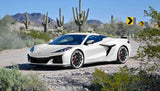 White Corvette with custom forged 2-piece wheels, parked in desert landscape with cacti and mountains in the background