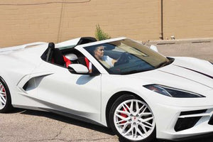 White Corvette C8 showcasing custom aftermarket wheels and rims at a car show, featuring eye-catching design and detailing.