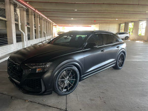 Front three-quarter view of a matte black 2023 Audi RS Q8 on RVRN RV-DC02 22 inch custom forged wheels in a parking garage