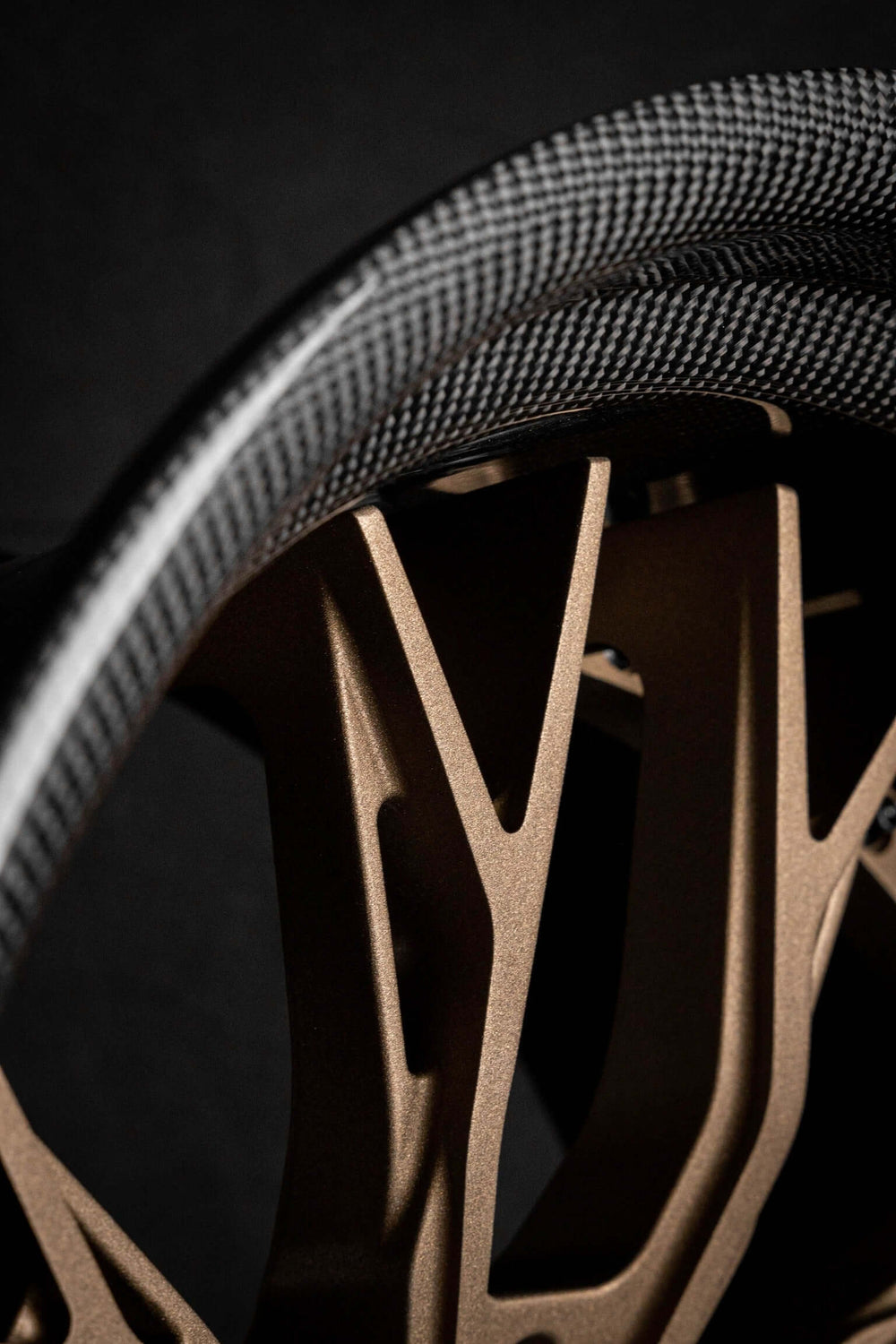 Close-up of a custom forged step lip wheel with a deep dish design, showcasing a sleek bronze finish and carbon fiber details.