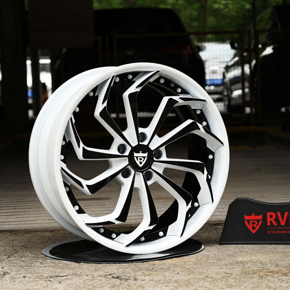 Custom forged Corvette C8 wheels featuring striking white and black rims, displayed prominently with branding.
