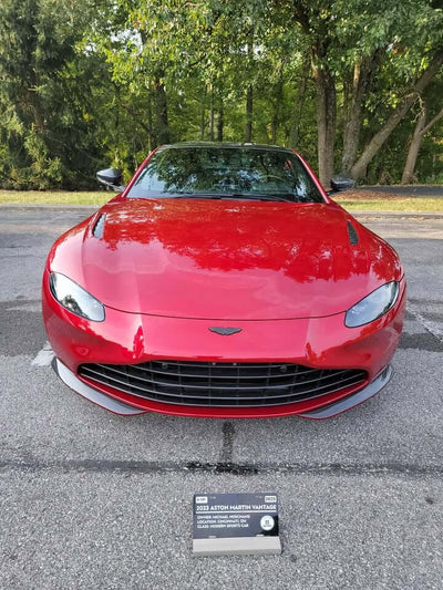 Red Aston Martin V8 Vantage showcasing stylish carbon fiber rims and distinctive front design.
