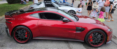 Aston Martin V8 Vantage featuring sleek carbon fiber rims and RVRN wheels, showcasing a striking red and black design.