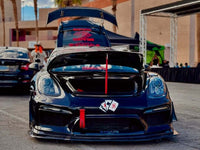 Custom Porsche Cayman with deep lip forged wheels, showcasing a sleek black design and performance modifications at a car event.