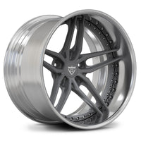 A multi-spoke alloy wheel rim with a polished silver outer barrel and a dark gray center and spokes, featuring a shield logo in the middle, shown on a white background.