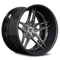 A custom multi-spoke alloy wheel rim with a glossy black lip, a carbon fiber pattern inner barrel, and polished chrome spokes. The center cap features a shield logo with a stylized letter 'R'.