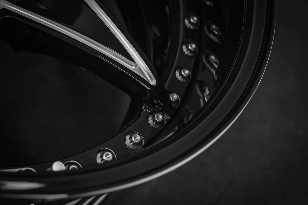 Close-up of custom forged wheel for Jeep Wrangler, showcasing sleek design and black finish with polished accents.