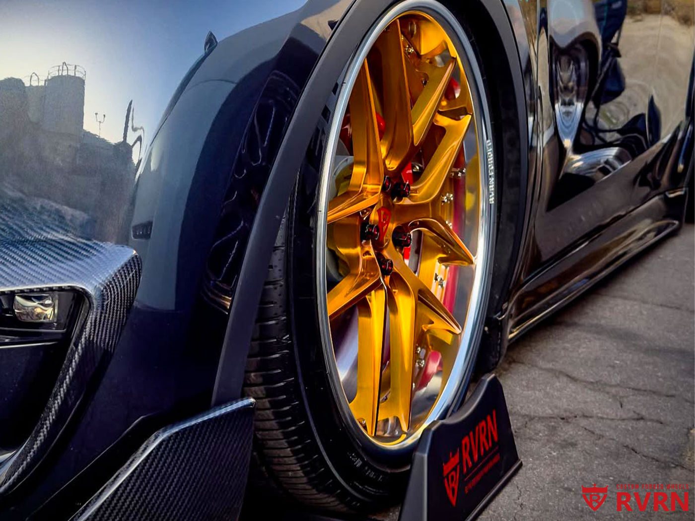 Close-up of RVRN RV-DR08 Polished Aluminum rim and Transparent Dark Gold spokes on Tesla Model Y Performance