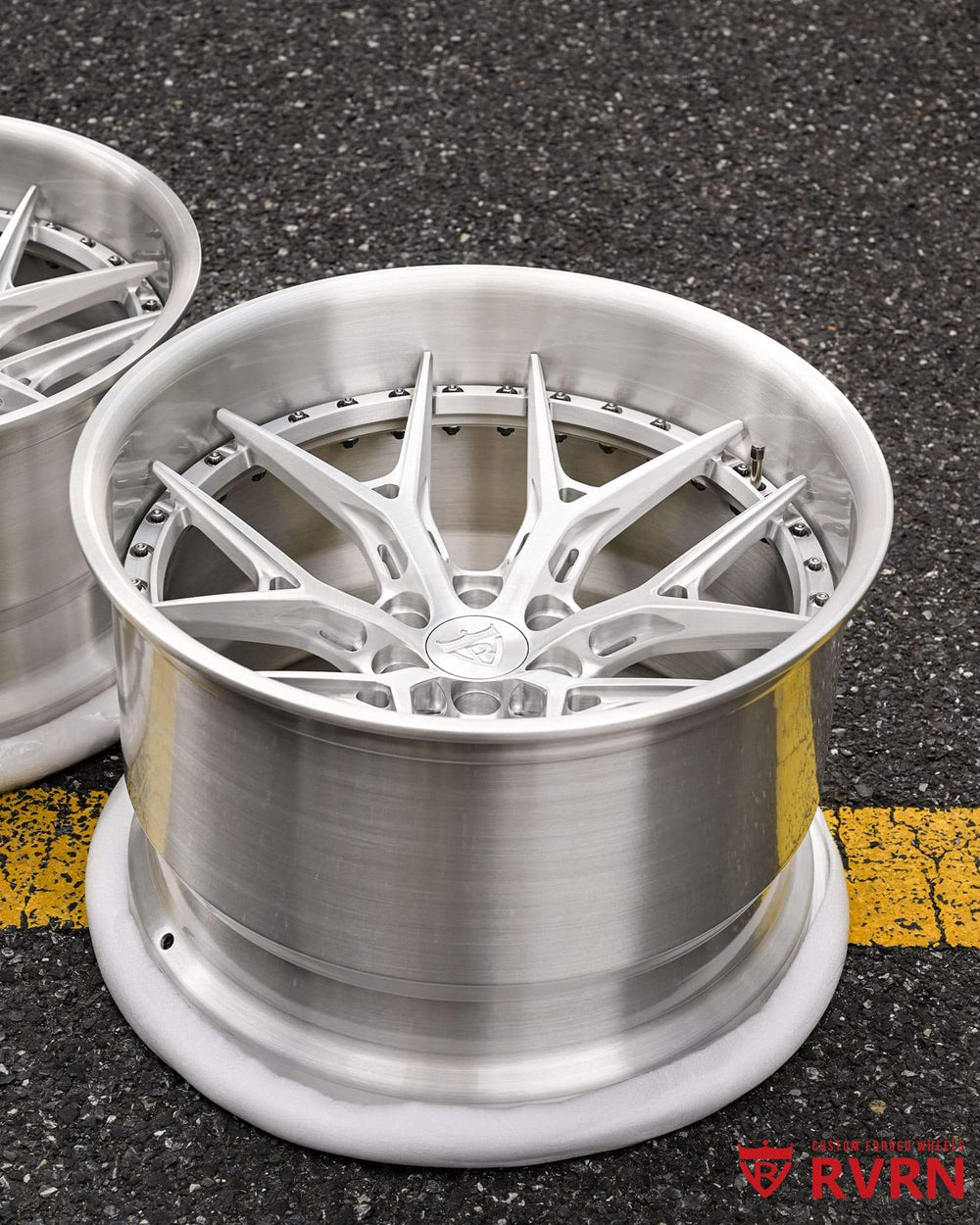 Three-quarter view of the brushed aluminum RVRN RV-DR08D forged wheel on the shop pavement, 2004 Dodge Viper
