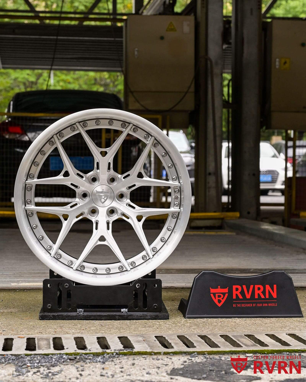 Face-on view of the brushed aluminum RVRN RV-DR08D forged wheel on a display stand in the workshop