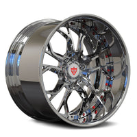 A polished chrome multi-spoke alloy wheel rim with a red and white shield logo in the center, shown on a clean white background.