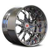 A polished chrome multi-spoke alloy wheel rim with a red and white shield logo in the center, shown on a clean white background.