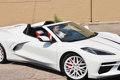C8 Corvette with white rims, showcasing aftermarket wheels and a sleek design on a sunny day.