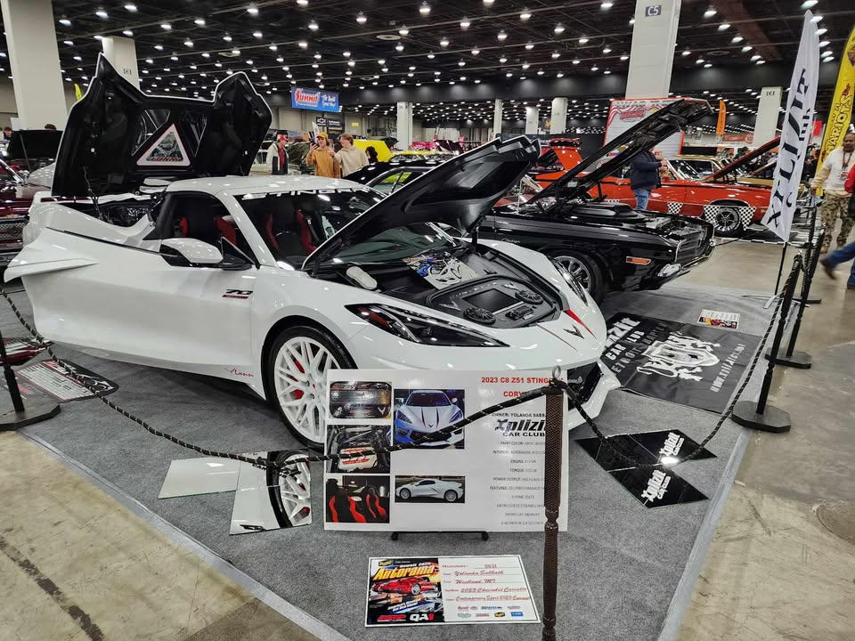 C8 Corvette with white rims showcased at a car show, displaying aftermarket wheels and sleek design.