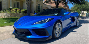 Front three-quarter view of a Riptide Blue 2024 Corvette C8 Stingray on RVRN RV-MC65 brushed aluminum forged wheels, stone house behind