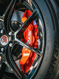 Close-up of 2023 Dodge Challenger Hellcat wheel featuring custom forged 20-inch staggered rvrn rims and red brake calipers.