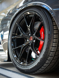 Close-up of custom 20-inch staggered rvrn concave rims on a 2023 Dodge Challenger Hellcat with red brake calipers.