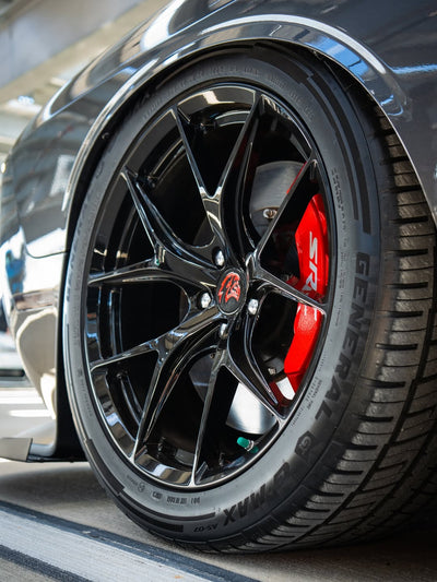 Close-up of custom 20-inch staggered rvrn concave rims on a 2023 Dodge Challenger Hellcat with red brake calipers.