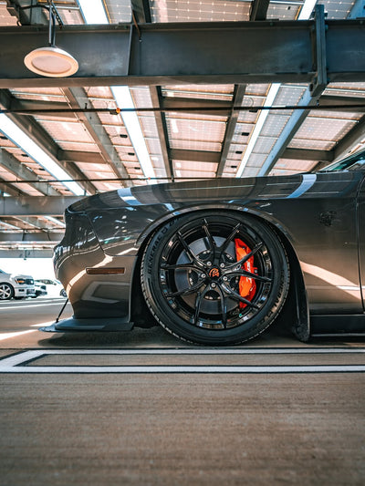 2023 Dodge Challenger Hellcat showcasing custom forged 20-inch staggered rvrn concave rims and striking red brake calipers.