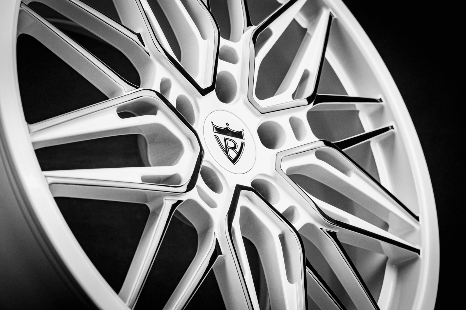 Custom forged Corvette C7 wheels featuring striking white and black rim design with intricate spokes.