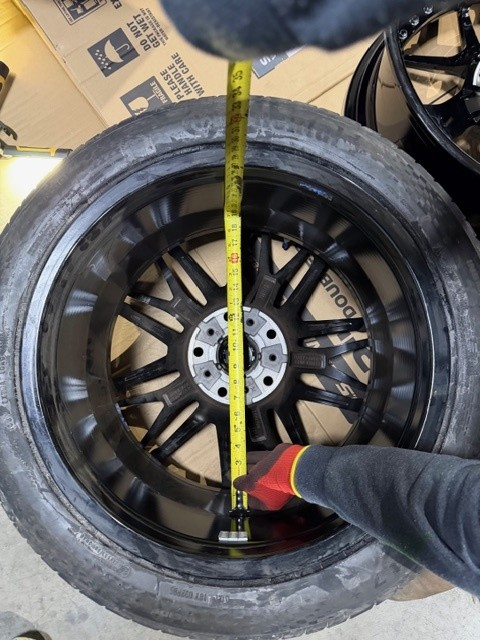 Technical inspection of front brake caliper interference on a 2026 BMW M5 G90 during custom wheel installation.
