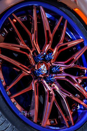 Close-up of custom 22-inch forged wheels on a vehicle, showcasing intricate design and vibrant colors.