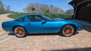 Custom Corvette C4 with RVRN forged wheels, showcasing unique orange rims against a stunning blue exterior.