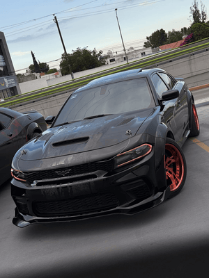 Front three-quarter view of a black 2023 Dodge Charger Hellcat Widebody on RVRN RV-DC39 deep dish rose gold wheels, parking deck