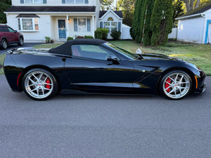 2016 Black C7 Corvette with chrome wheels parked outside, showcasing custom forged wheels and sleek design.