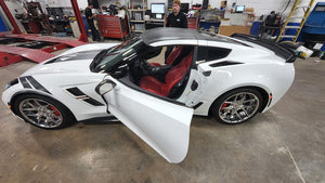 2017 C7 Corvette Grand Sport with aftermarket wheels and open door, showcasing its sleek design and custom features.