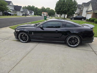 2011 Ford Shelby GT500 with custom forged black and chrome rims parked in a residential area.