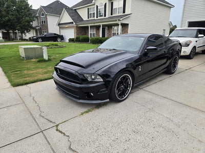 2011 Ford Shelby GT500 with custom forged black and chrome RVRN RV-DR08D wheels parked in residential driveway.