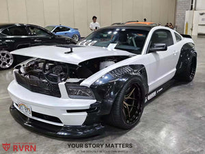 Front three-quarter view of a white 2007 Ford Mustang Widebody with bronze RVRN RV-DR08D deep dish wheels at an indoor show