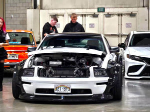 Front view of a white 2007 Ford Mustang Widebody with black fender flares on RVRN RV-DR08D deep dish wheels, hood open