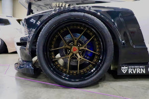 Close-up of the gloss bronze RVRN RV-DR08D wheel with black barrel and gold rivets on a white 2007 Ford Mustang Widebody