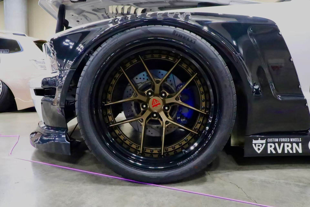 Detailed view of the gloss bronze RVRN RV-DR08D deep dish wheel and blue brake caliper on a 2007 Ford Mustang Widebody