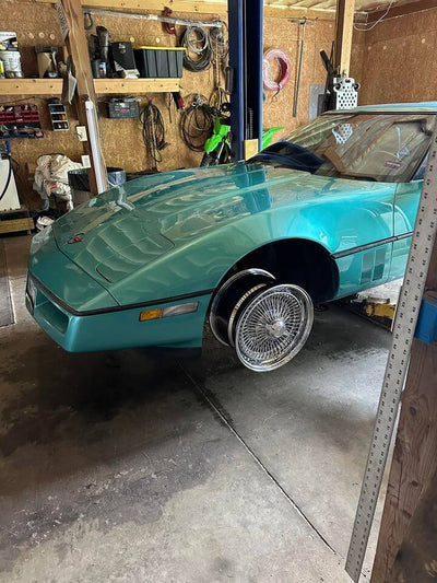 Front angle of 1990 Corvette C4 on RVRN DR90 chrome deep dish wire wheels, 17x9.5 with 2-blade caps, showcasing vintage design with modern forged quality.
