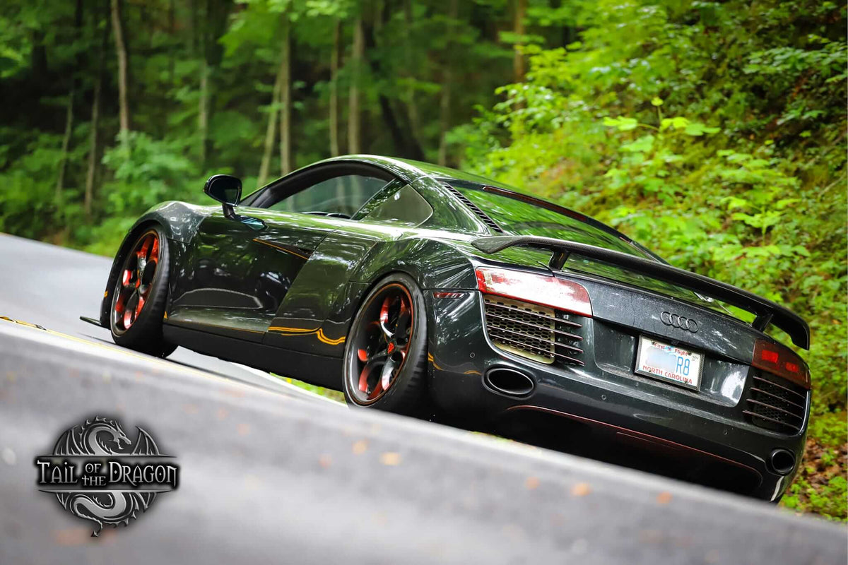 Rear three-quarter view of a black 2008 Audi R8 on RVRN RV-DS016 custom forged wheels with red spoke accents on a mountain road