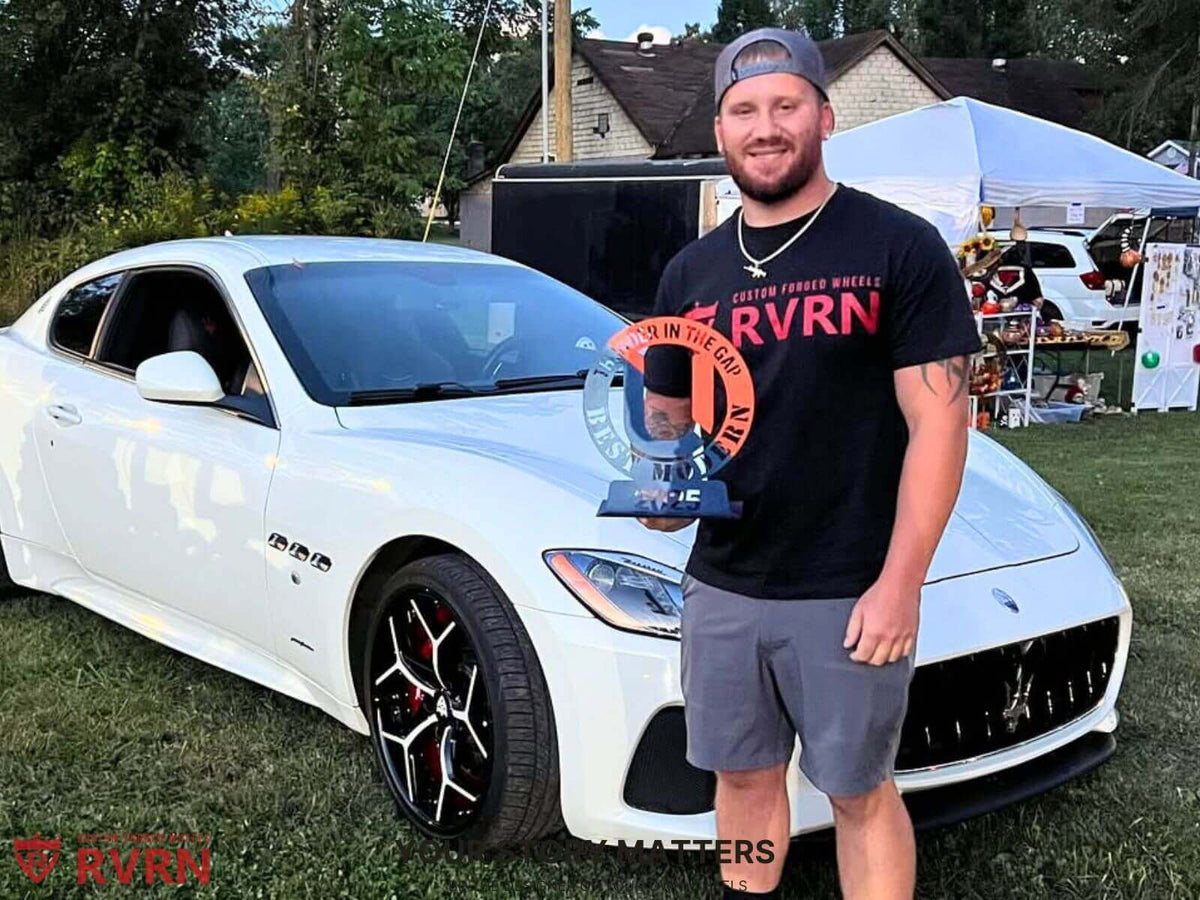 RVRN customer showcasing custom forged wheels at a car show, proudly holding an award next to a white luxury vehicle.