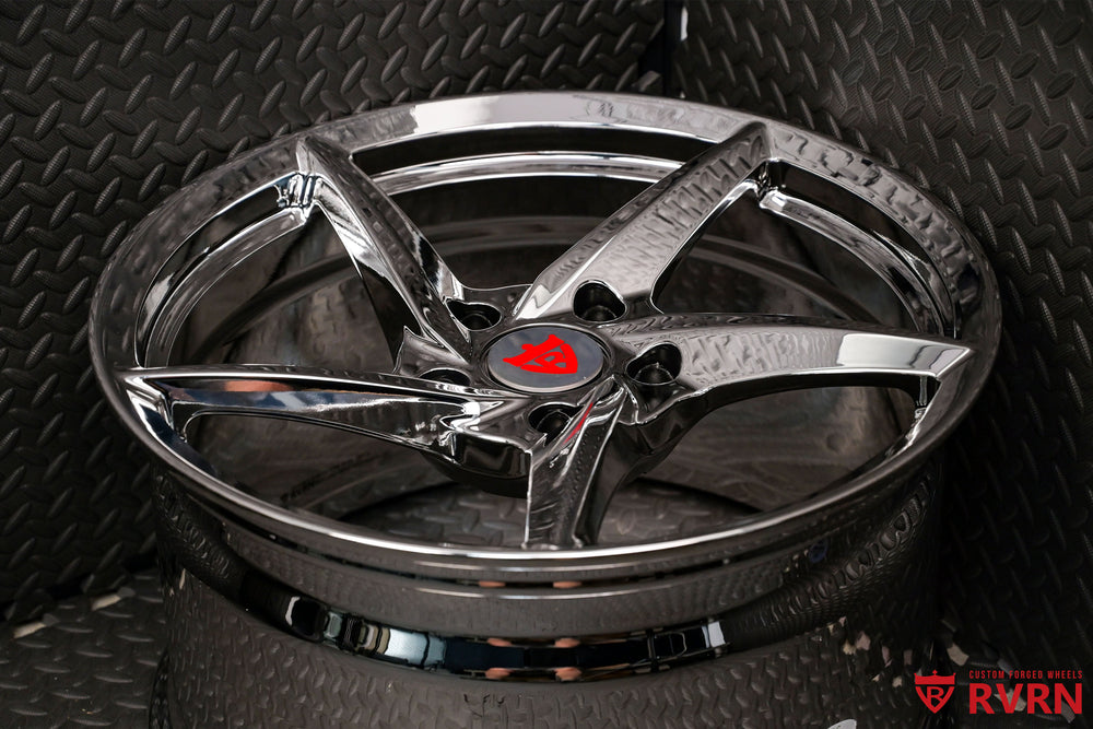 Porsche 911 aftermarket 5 spoke chrome rims showcased on a textured surface, highlighting high-quality design and style.