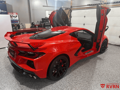 2021 Corvette C8 Z51 in vibrant red, showcasing aftermarket RVRN red and black wheels in a garage setting.