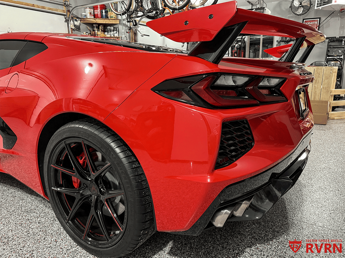 2021 Corvette C8 Z51 featuring eye-catching red and black RVRN aftermarket wheels in a garage setting.