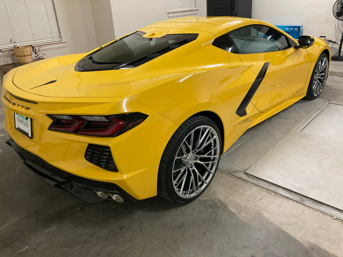 Rear three-quarter view of a yellow 2026 Corvette C8 LT1 Coupe on RVRN RV-MC65 chrome concave wheels in a garage