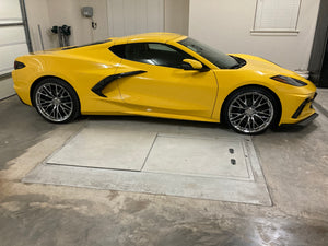 Side profile of a yellow 2026 Corvette C8 LT1 Coupe on RVRN RV-MC65 chrome concave wheels parked inside a garage