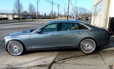 Cadillac CT6 with custom 24 inch brushed aluminum forged wheels and floating center caps on display.