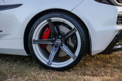 2023 Corvette C8 Z06 with custom concave carbon flash wheels and red brake calipers on grass.