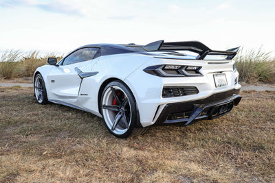 2023 Corvette C8 Z06 with custom carbon flash rims and concave wheels parked on grass.